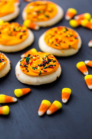 Halloween sugar cookies with oranges icing and sprinkles on top.の写真素材