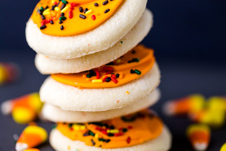 Halloween sugar cookies with oranges icing and sprinkles on top.