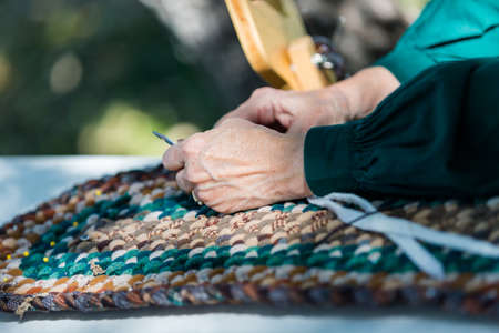 Making a rug with vintage materials by old woman.の写真素材