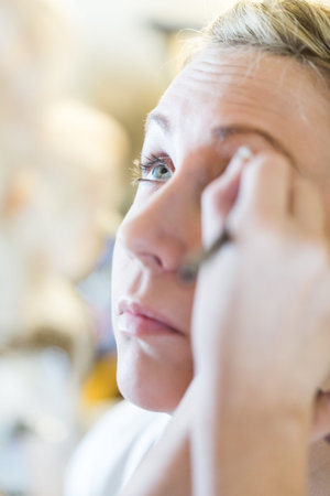 Makeup artist applying make up to the brides face.