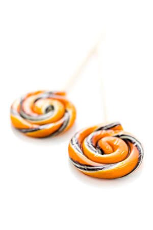Handmade twist lollipop with orange and black stripes.の写真素材