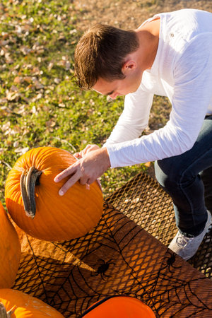 Carving big orange pumpkins for Halloween in late Autumn.の写真素材