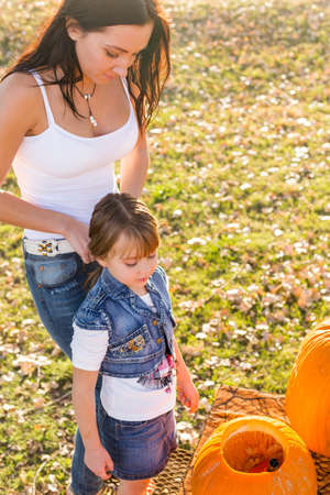 Carving big orange pumpkins for Halloween in late Autumn.の写真素材