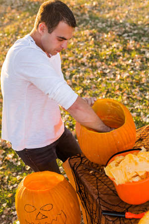Carving big orange pumpkins for Halloween in late Autumn.の写真素材