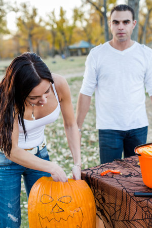 Carving big orange pumpkins for Halloween in late Autumn.の写真素材