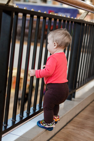 Cute baby girl shopping with her parents in the shopping mall.