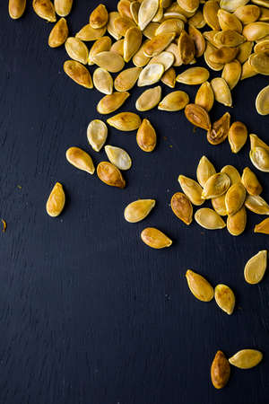 Home  cooked pumpkin seeds on black background.の写真素材