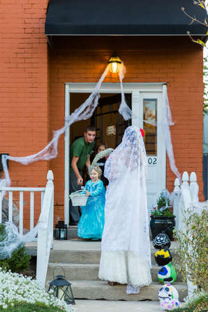 Denver, Colorado, USA-October 31, 2014. Trick or treating in costumes on Halloween night.のeditorial素材