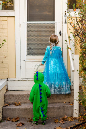 Trick or treating in costumes on Halloween night.