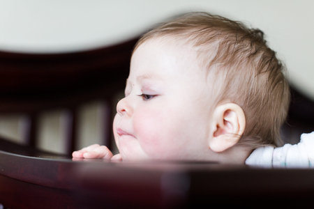 Cute baby girl standing in her crib.
