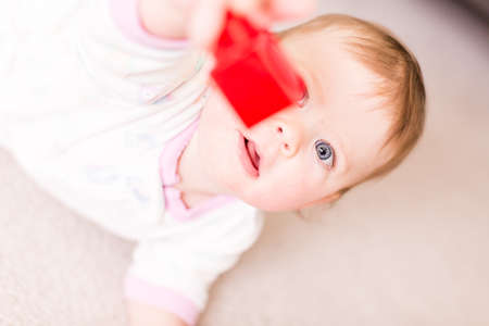 Cute baby girl playing with cubes on the floor.の写真素材