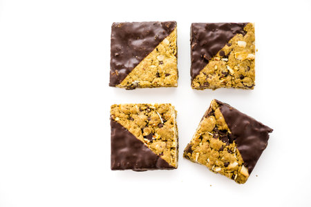 Vegan Cowgirl Squares dippen in chocolate on a white background.の写真素材