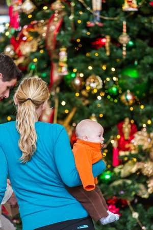 Denver, Colorado, USA-November 23, 2014. Mother with baby boy standing at front of Christmas tree.のeditorial素材