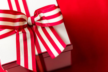 Christmas present wrapped in the box with red and white ribbon.の写真素材