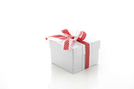 Christmas present wrapped in the box with red and white ribbon.の写真素材