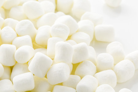 Small round white marshmallows on a white backgrouns.の写真素材