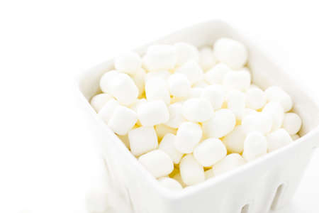 Small round white marshmallows on a white backgrouns.の写真素材