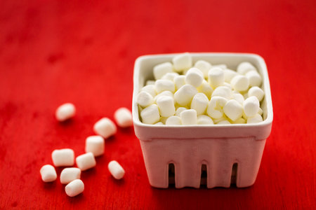 Small round white marshmallows on red backgrouns.の写真素材