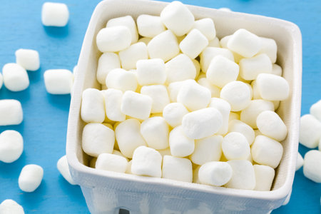 Small round white marshmallows on blue backgrouns.
