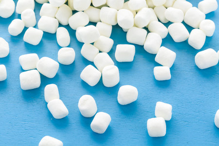 Small round white marshmallows on blue backgrouns.の写真素材