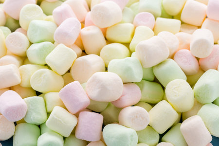 Small round multicolor marshmallows on blue backgrouns.の写真素材