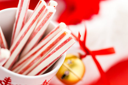 Peppermint stirrers in white cup with red snowflakes.の写真素材