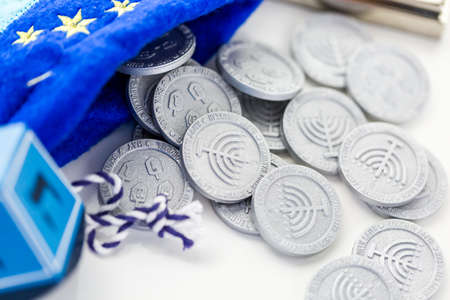 Blue dreidel with silver tokens on a white backgroundの写真素材