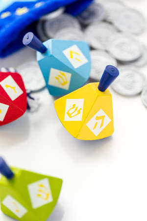 Colorful dreidels with silver tokens on a white backgroundの写真素材