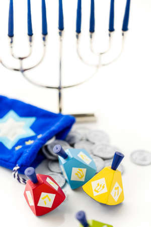 Colorful dreidels with silver tokens on a white backgroundの写真素材