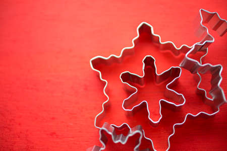 Different size metal cookie cutters in shape of snow flakes.の写真素材