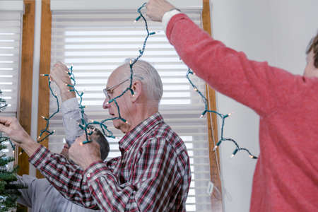 Family decorating beautiful live Christmas tree.の写真素材
