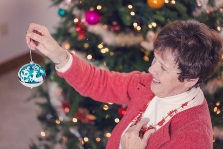 Family decorating beautiful live Christmas tree.