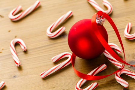 Red Christmas ornaments on stained wood table.の写真素材