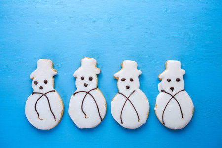 Frosted white sugar cookies in shape of snowman.
