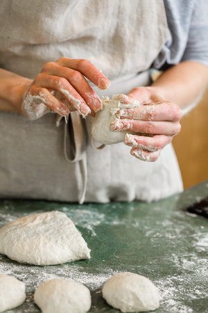 Young baker preparing artisan sourdough dinner rolls.