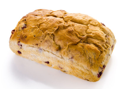 Freshly baked sourdough cranberry but bread on a white background.