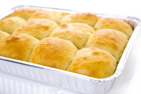 Freshly baked sourdough dinner rolls on a white background.