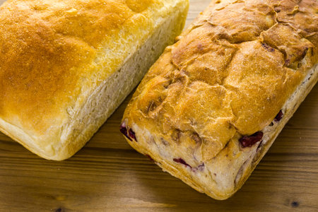 Freshly baked sourdough breads on wood cutting board.の写真素材