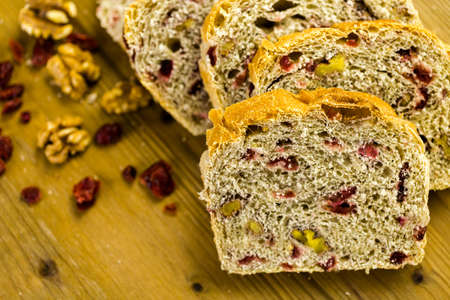 Freshly baked sliced sourdough cranberry nut bread on the table.の写真素材