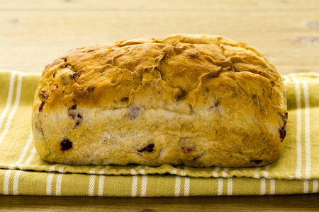 Freshly baked sourdough cranberry nut bread on a white background.