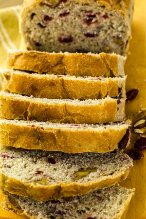 Freshly baked sliced sourdough cranberry nut bread on the table.