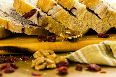 Freshly baked sliced sourdough cranberry nut bread on the table.の写真素材