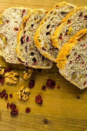 Freshly baked sliced sourdough cranberry nut bread on the table.の写真素材