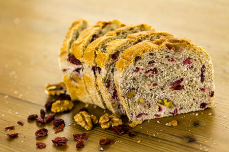 Freshly baked sliced sourdough cranberry nut bread on the table.の写真素材