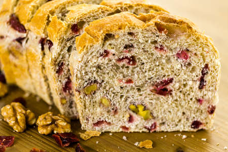 Freshly baked sliced sourdough cranberry nut bread on the table.の写真素材