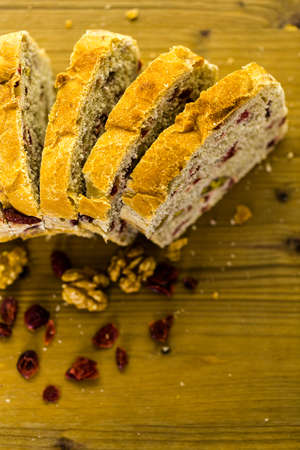 Freshly baked sliced sourdough cranberry nut bread on the table.の写真素材