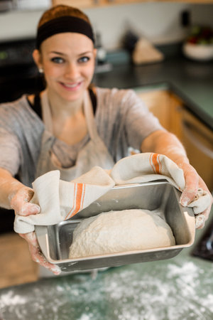 Young baker preparing artisan sourdough bread.
