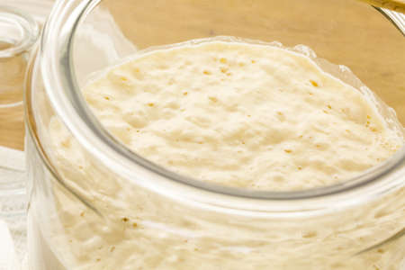 Sourdough starter in large glass jar on the table.の写真素材