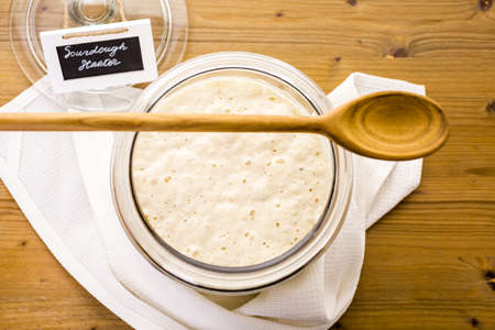 Sourdough starter in large glass jar on the table.の写真素材