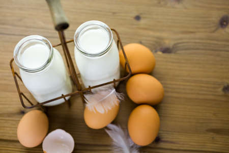 Fresh farm eggs and milk on wood table.の写真素材